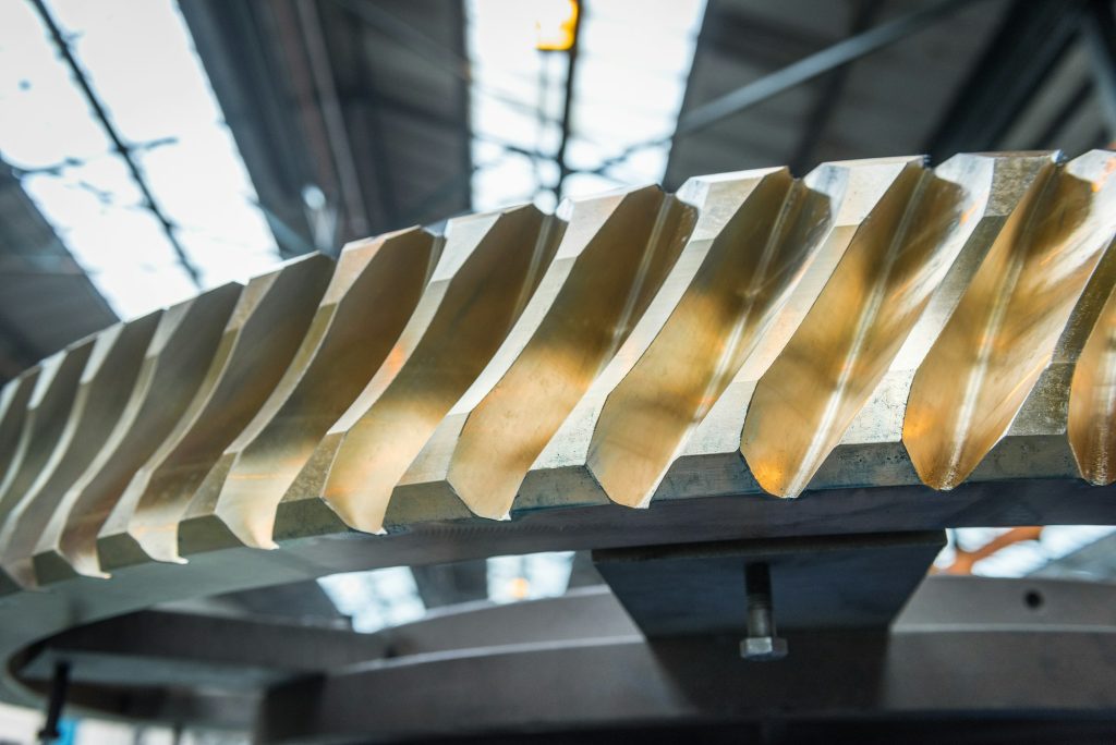 Close up of bronze worm gear wheel in engineering factory